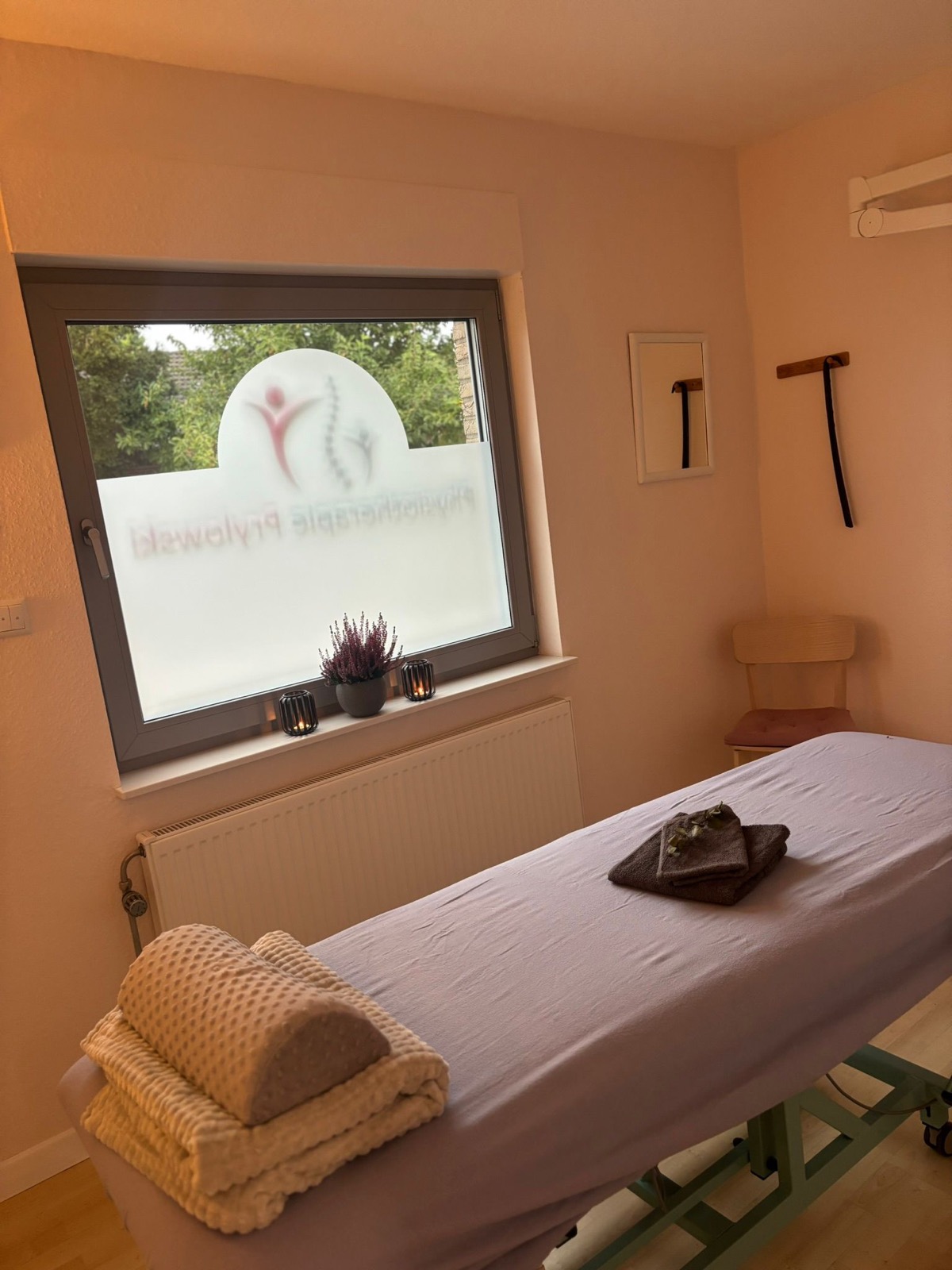 Behandlungsraum mit Massageliege und Handtüchern